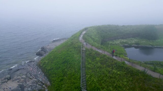 Aerial view of Suomenlinna on a foggy, rainy day, with a man walking and enjoying the moment