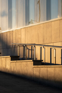 Modern architecture concrete stairs with railing as sunlight casts shadows in minimal lines and geometry for clean urban design detail