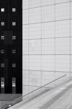 Modern architecture facade with grid panels and minimal lines showing contrast beside stairs in clean monochrome urban composition graphic
