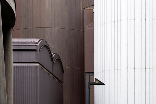 Modern architecture facade in metal with minimal curves pattern and industrial lines creating abstract contemporary building detail