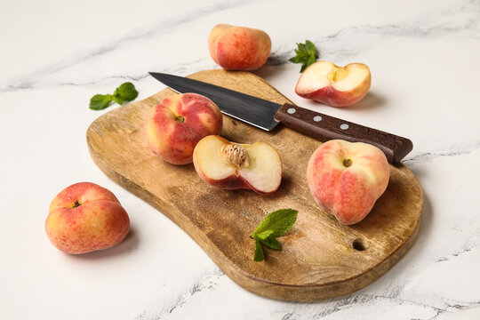 Wooden board with sweet fig peaches and mint on white background