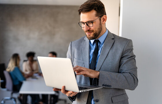 Young businessman using laptop computer in office. Manager thinks about successful financial ideas