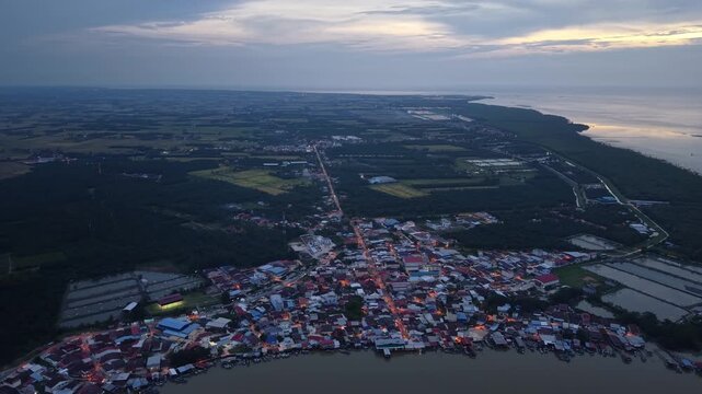 Nighttime aerial footage of Sungai Udang coastal village showing lights, roads and surrounding landscape.