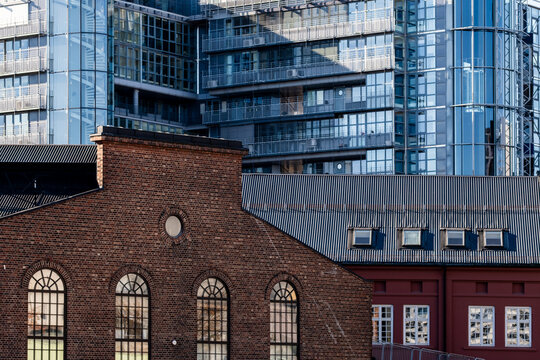 Urban architecture in Oslo city skyline pairs a modern skyscraper with a brick warehouse creating contrast and a story of renewal today