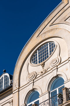 Historic classic architecture reveals an elegant stucco facade with ornament window detail under open sky in a timeless city mood today