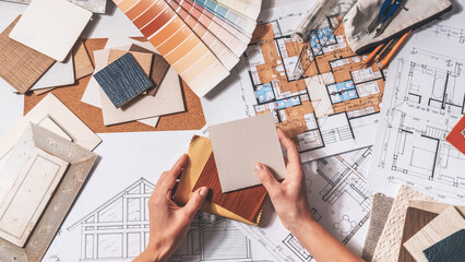 Interior design planning with architectural drawings, color swatches and material samples, residential renovation concept, finish selection and home design workflow. © shintartanya