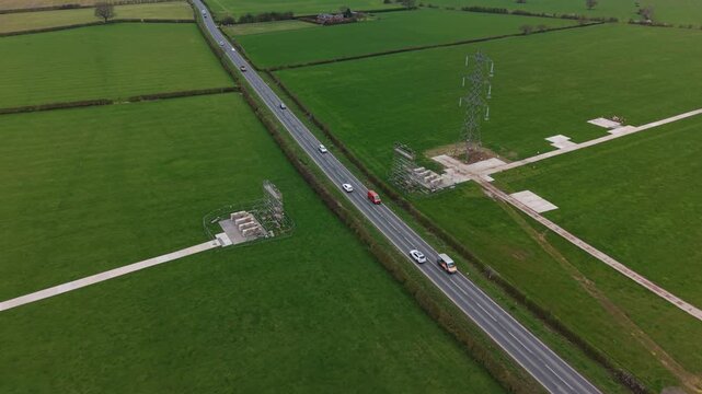 Scaffold over road secures cables during road works in rural setting