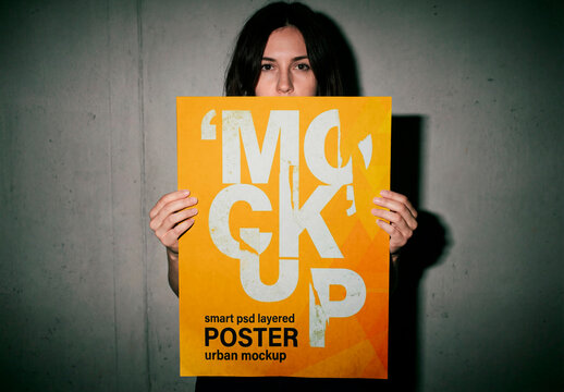 Woman holding blank poster mockup against dark wall background