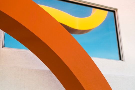 Abstract modern architecture with curved orange lines and blue sky background