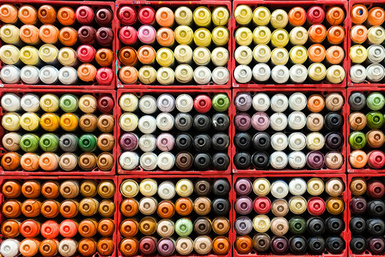 Colorful spray paint cans arranged in grid pattern creative background texture