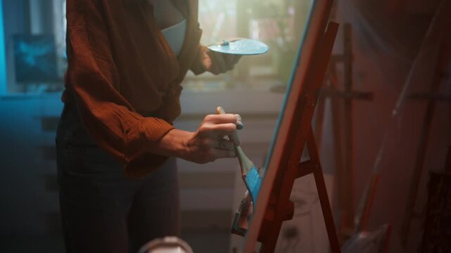 Female Painter Preparing Her Artwork. Closeup Of Woman Mixing Paint In Studio Setting