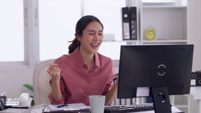Asian adult businesswoman celebrating success achievement working at home office desk enjoying triumph moment positive business results project completion