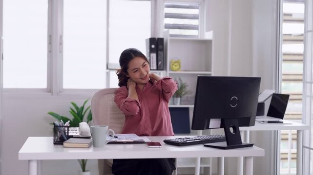 Asian adult woman worker stretching arms relieve tension fatigue practicing ergonomics during work from home office environment break
