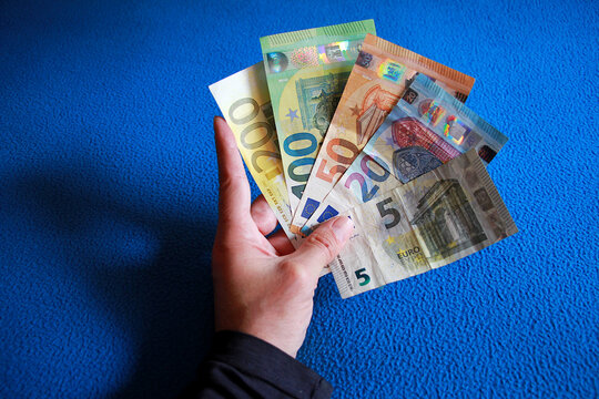 Dinero efectivo cash en billetes de euro por colores en mano