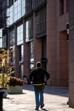 Modern urban architecture frames a pedestrian on Oslo Norway street as sunlight and shadow shape lifestyle and everyday city movement