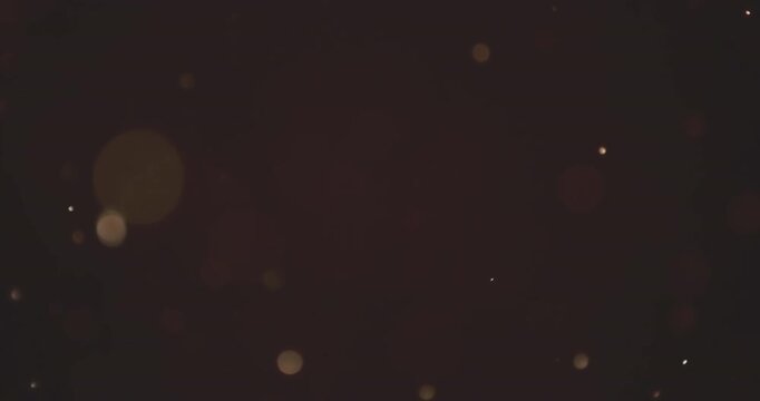 abstract motion loop of floating golden bokeh particles on dark background, christmas event