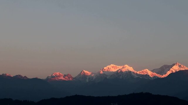 This image appears to be a photograph of Mount Kanchenjunga in the Himalayas at sunrise.