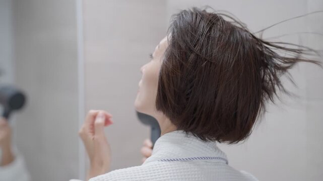 風呂上がりにドライヤーをする女性
