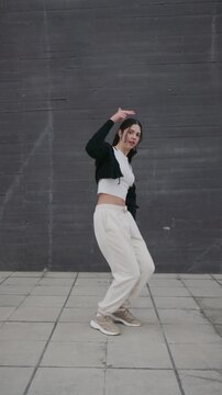 Young woman performing afrobeat hip hop dance routine outdoors