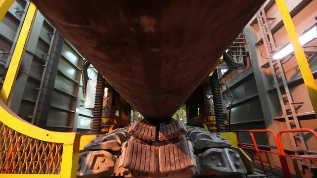 Close up video of large steel pipeline section moving toward camera on welding conveyor inside industrial production line with rollers support frames and factory machinery heavy machinery steel