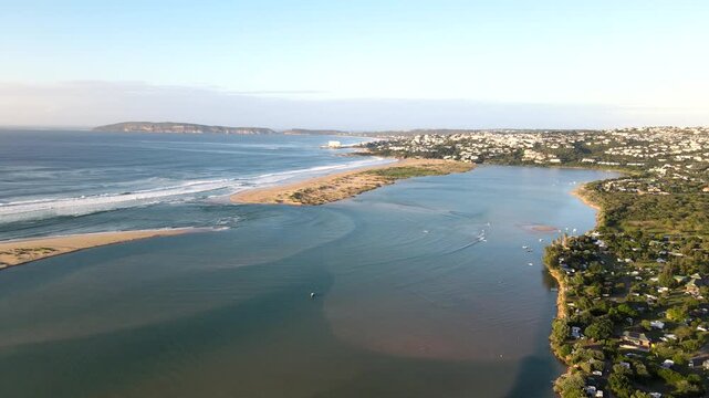 Sunrise drone pullback over Keurbooms river lagoon mouth and Plettenberg Bay