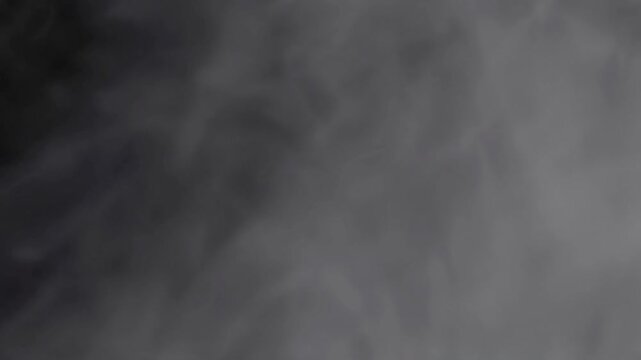 black and white smoke explosion slowly floating through space against black background