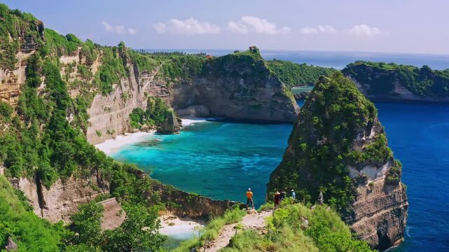Aerial view of diamond beach with turquoise water, palm trees, and rocky cliffs in nusa penida, bali
