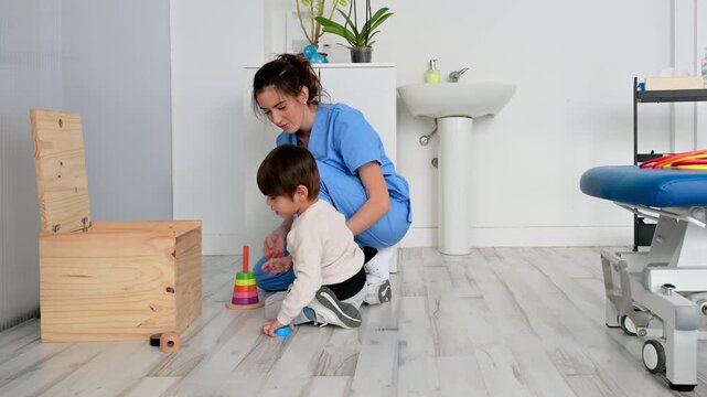 Child with disability performing motor skills exercises with physiotherapist using educational game. Pediatric rehabilitation, coordination development, therapy and healthcare concept. High quality 4k