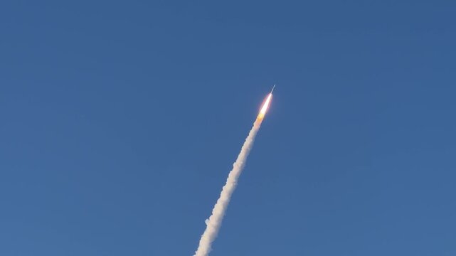 Space rocket rising after launch through blue sky with fire trail and exhaust smoke in Florida, USA - Cinematic, stabilized