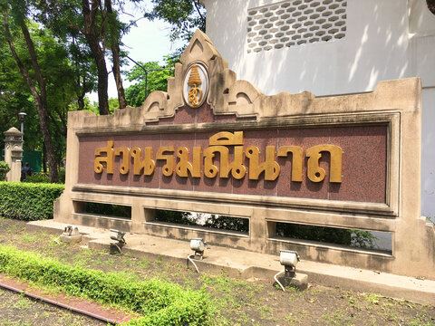 Romaneenart Park entrance sign with golden Thai lettering and royal emblem in a public green space near the Grand Palace area - Thailand, June 28, 2017