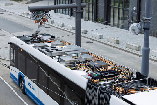 Amsterdam, Netherlands, April 11, 2026. Close-up overhead perspective of a charging pantograph connected to the roof of an electric GVB bus for rapid charging.
