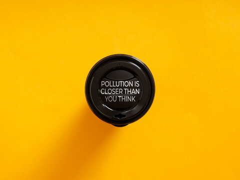 Black plastic coffee cup lid saying pollution is closer