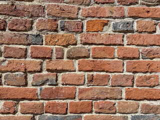Fototapeta premium Brick wall with various colors and textures located in a urban area during daylight hours
