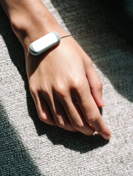 Wearable stress sensor on wrist, modern health technology for monitoring relaxation and emotional well being, close up hand, natural light