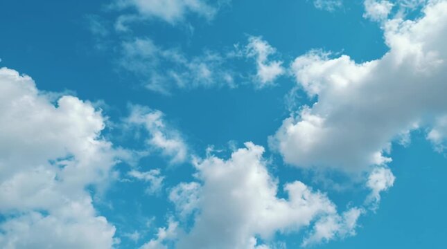 Celestial Canvas: A serene depiction of a bright blue sky adorned with fluffy, cotton-like clouds, capturing a sense of freedom and boundless expanse.
