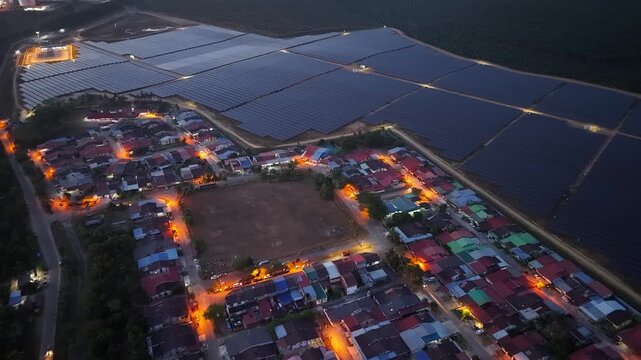 Aerial drone view of solar farm beside residential neighborhood at dusk