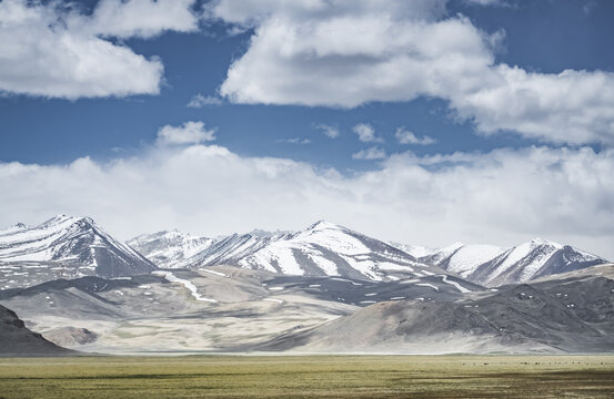 Mountain landscape with a view of a rocky ridge with snow and glaciers in the highlands of Tajikistan in the Pamirs. A panorama of the Tien Shan Mountains for background