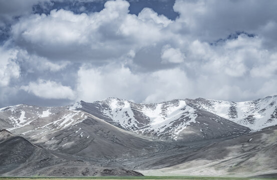 Mountain landscape with a view of a rocky ridge with snow and glaciers in the highlands of Tajikistan in the Pamirs. A panorama of the Tien Shan Mountains for background