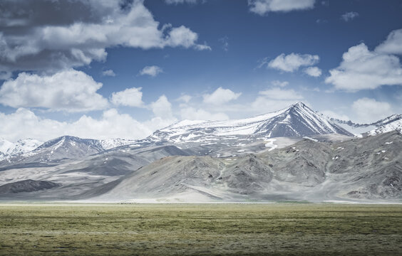 Mountain landscape with a view of a rocky ridge with snow and glaciers in the highlands of Tajikistan in the Pamirs. A panorama of the Tien Shan Mountains for background