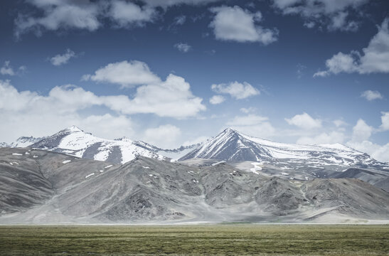 Mountain landscape with a view of a rocky ridge with snow and glaciers in the highlands of Tajikistan in the Pamirs. A panorama of the Tien Shan Mountains for background