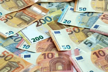 Obraz premium Euro money banknotes pile on table. Eurozone bills of EUR currency close up. Concept of economy