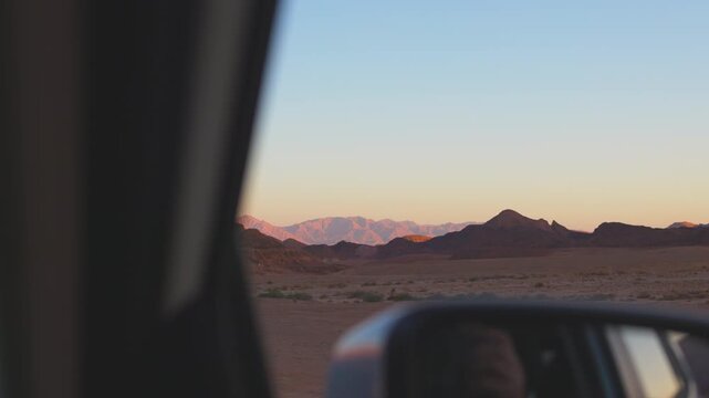 A road trip to Timna Park in Israel. A view from the car window of mountains in a desert landscape. Concept of travel and road trip.