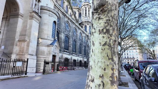 Static wide shot of the Saint-Augustin Church upper facade and rose window under a clear blue sky.