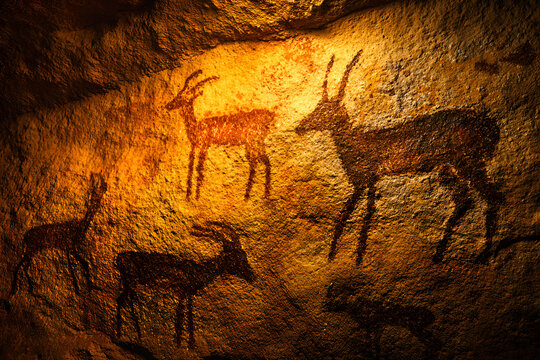 Ancient Cave Painting Depicting Antelopes and Deer on a Textured Rock Wall.