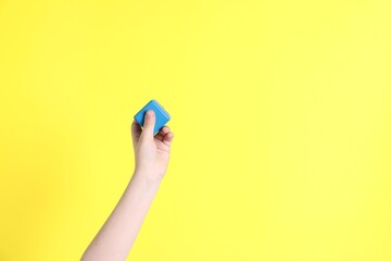 Fototapeta premium Child with blue cube on yellow background, closeup. Space for text