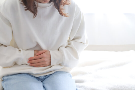 お腹の痛みを感じる女性