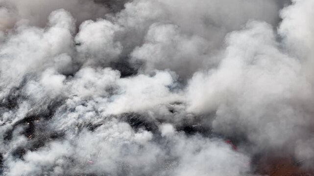 Aerial drone view of fire burning at landfill site