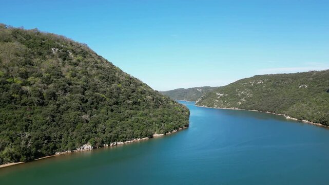 Aerial drone footage of Lim Channel, Croatia: fjord-like inlet with calm water, forested hills and dramatic natural landscape. Ideal for travel, nature and scenic projects.
