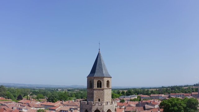 Aerial View of Stone Church Tower Above Village Rooftops and Horizon
