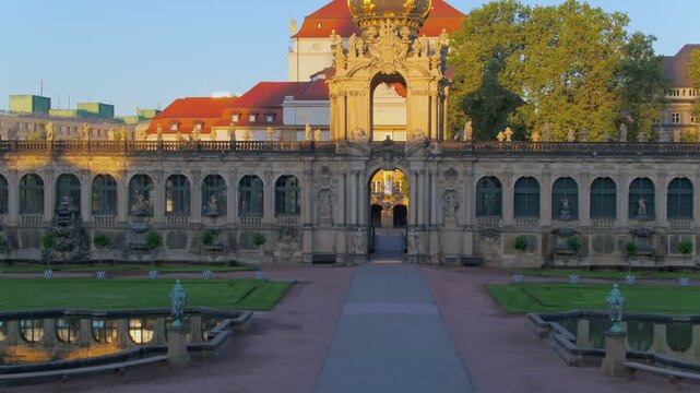 View of the Dresden Zwinger's Crown Gate in warm evening light. The Baroque facade and the courtyard with fountains look particularly magnificent during the golden hour.